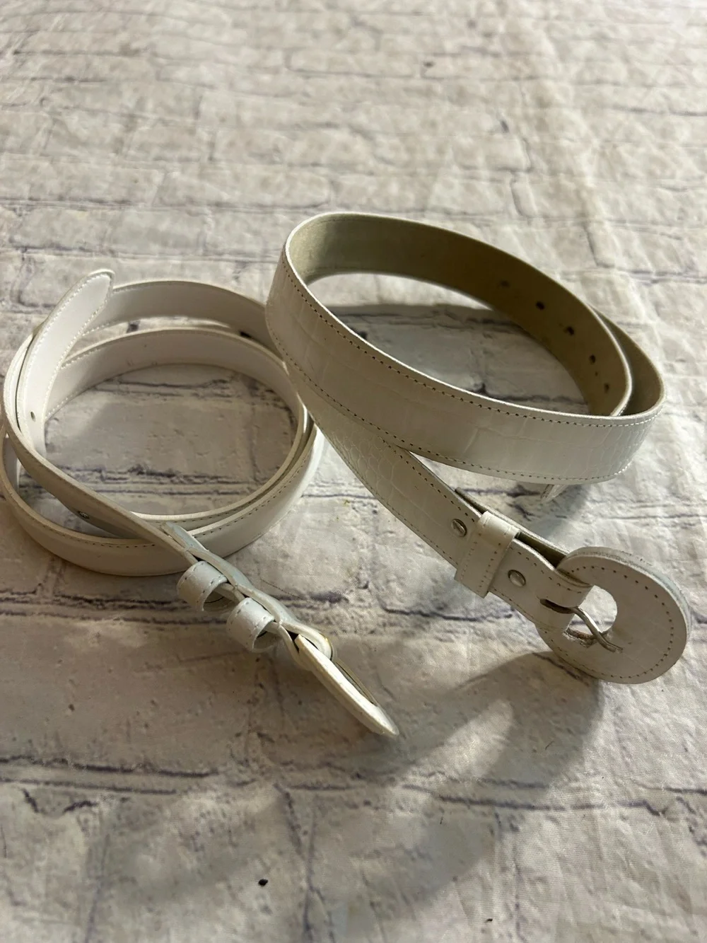 LOT OF (2) WHITE THIN WOMEN’S BELTS (1) GENUINE LEATHER BOTH COVERED BUCKLES